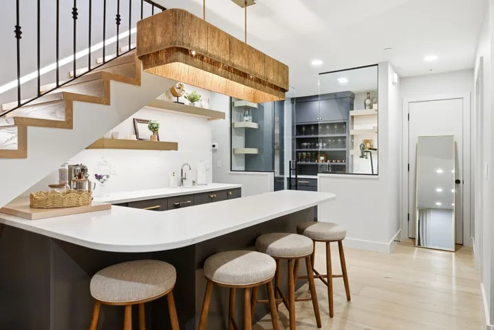 Built-in bar with dark cabinetry, white countertop, and integrated sink