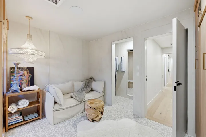Textured wall finishes with integrated lighting, wood-finish flooring, and built-in wood cabinetry