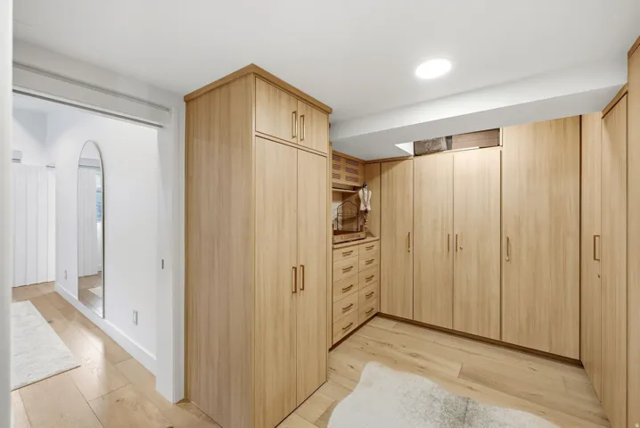 Custom built-in cabinetry with integrated drawers, wood-finish flooring, and recessed ceiling lighting
