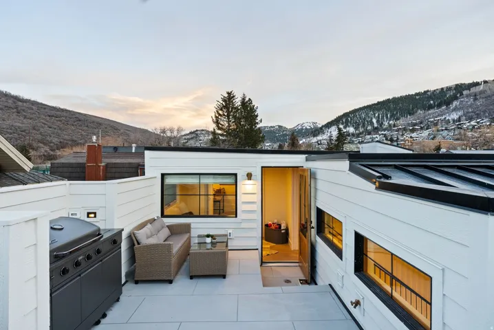 Rooftop patio with white plank siding and expansive mountain scenery