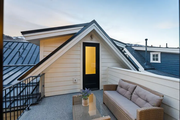Private balcony with durable flooring, exterior wall paneling, and black metal railings
