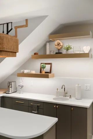Integrated wet bar with a circular undermount sink, a polished chrome faucet, and white countertops