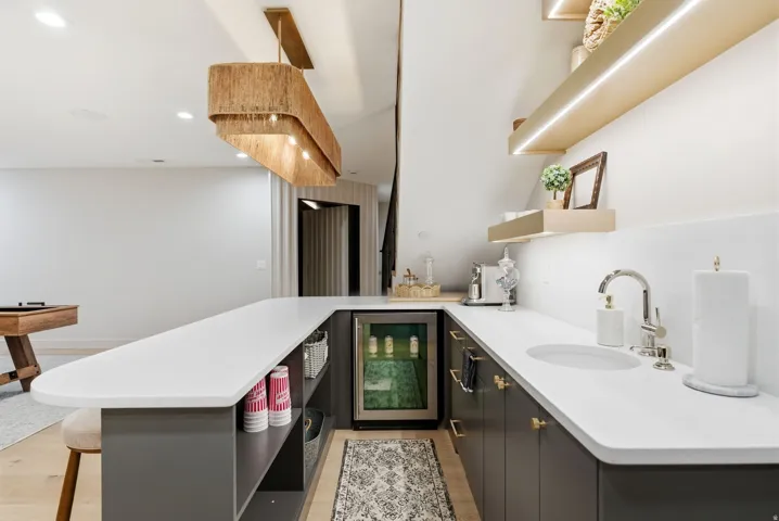 U-shaped bar with a built-in beverage refrigerator, integrated sink, and polished nickel faucet