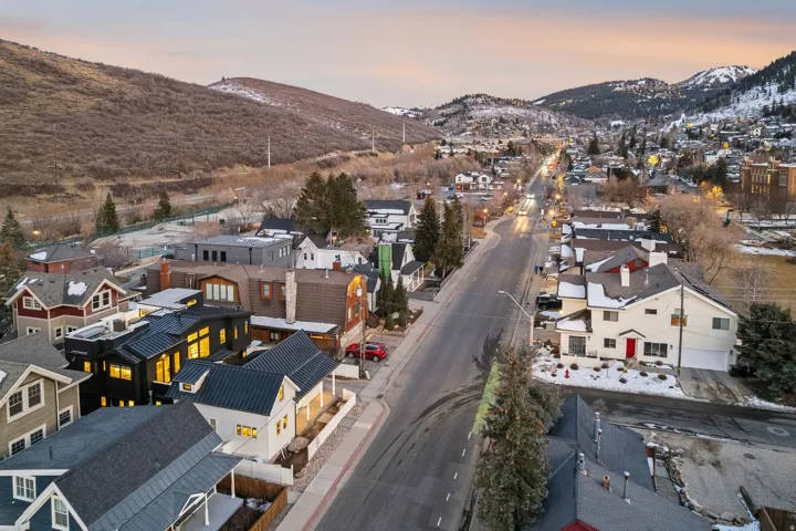 Residential streetscape featuring a variety of architectural styles, surrounded by natural mountainous terrain
