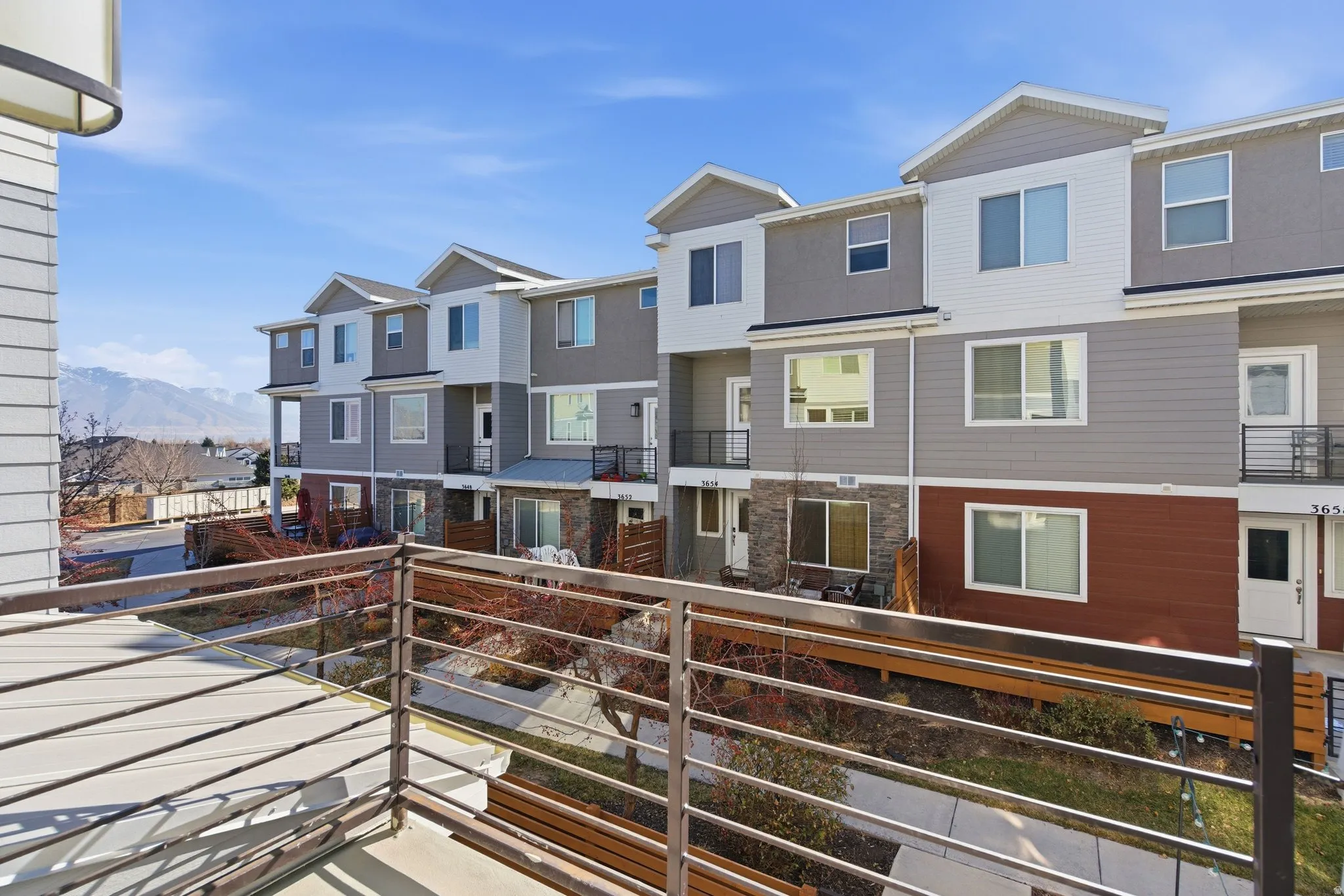 Multi-level townhome exterior featuring contemporary siding, stone veneer accents, and multiple windows