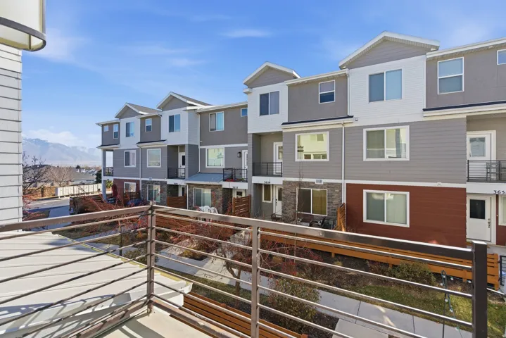 Multi-level townhome exterior featuring contemporary siding, stone veneer accents, and multiple windows