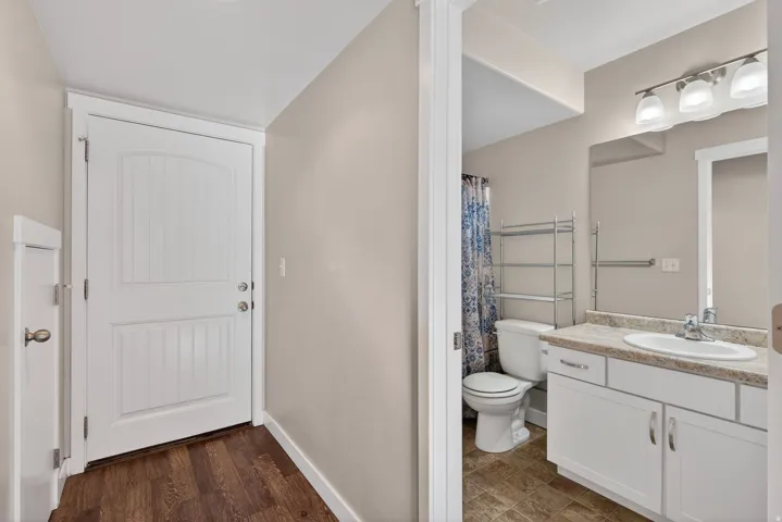 Wood-finish flooring and a white paneled door