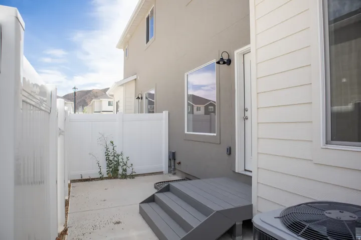 Private outdoor space with a concrete patio and white vinyl fencing