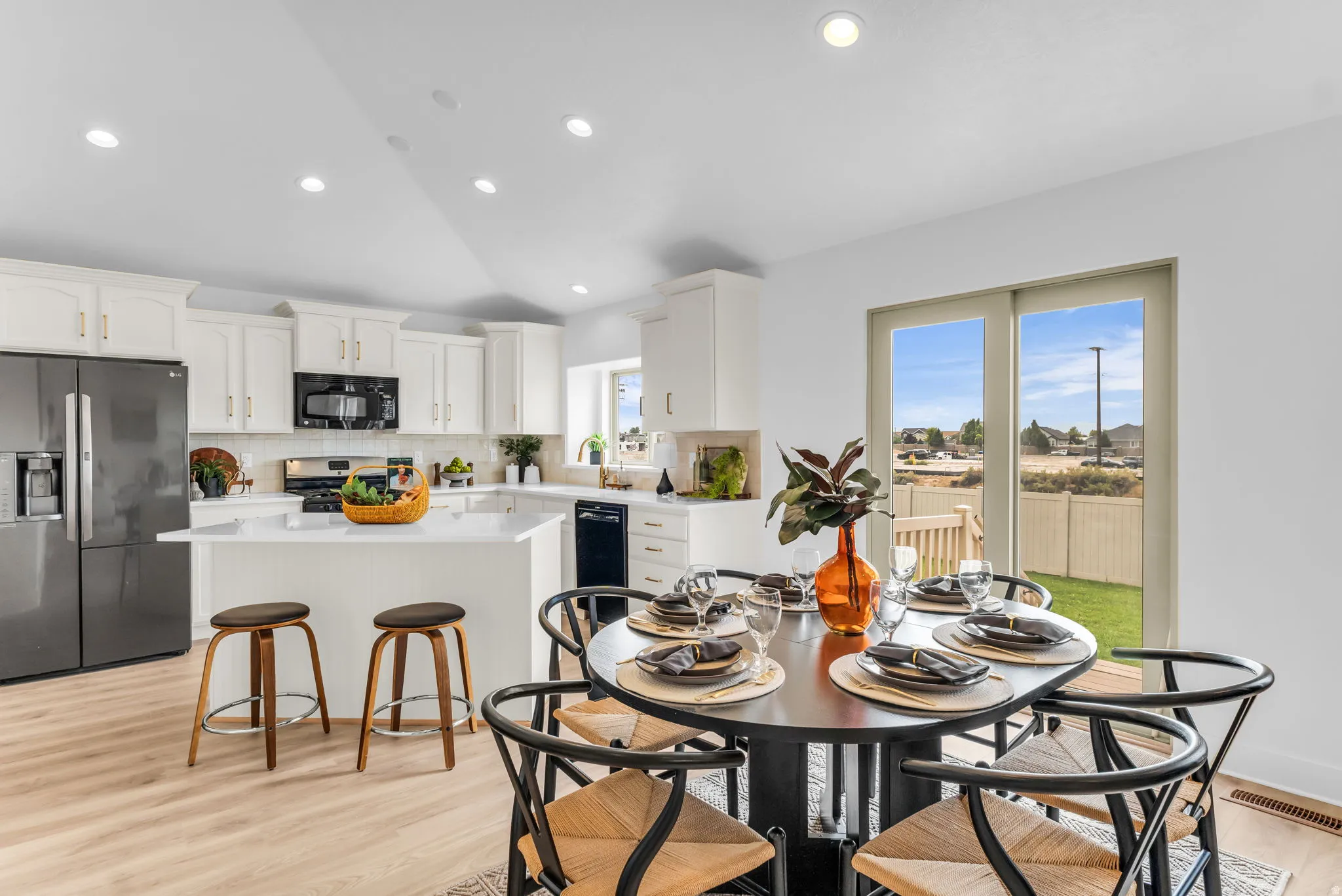 Kitchen featuring white cabinetry, a central island with countertop seating, stainless steel appliances, wood-finish flooring, and recessed lighting