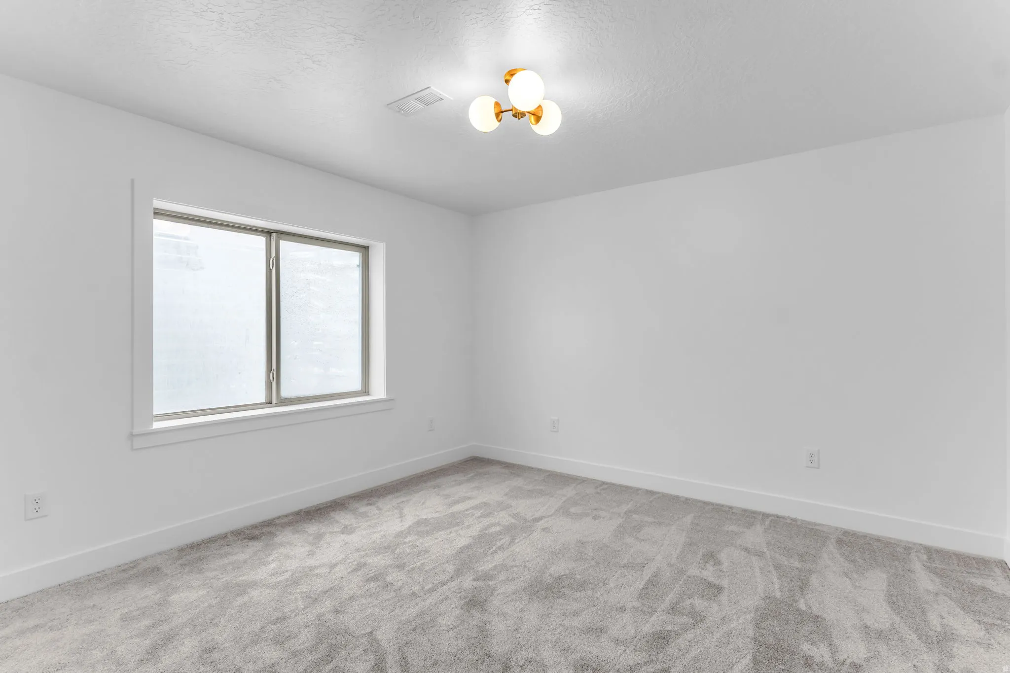 Neutral wall paint, light-toned carpet, recessed window, and contemporary ceiling light fixture