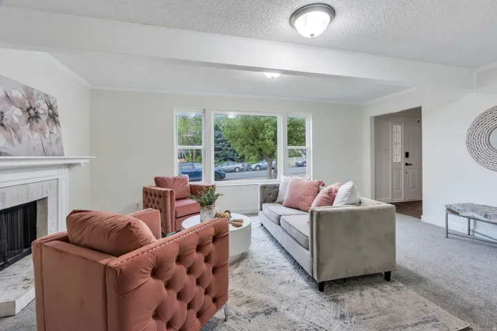 Natural light streaming through multiple windows, complemented by a white mantel with a tile surround, and a recessed entryway with a paneled door