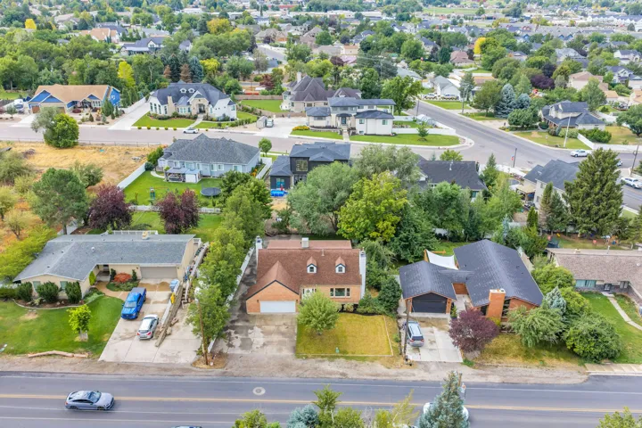 Aerial view of a residential neighborhood with diverse architectural styles, mature trees, and paved streets