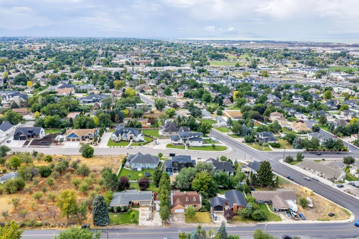 Residential landscape featuring mature trees and paved roadways