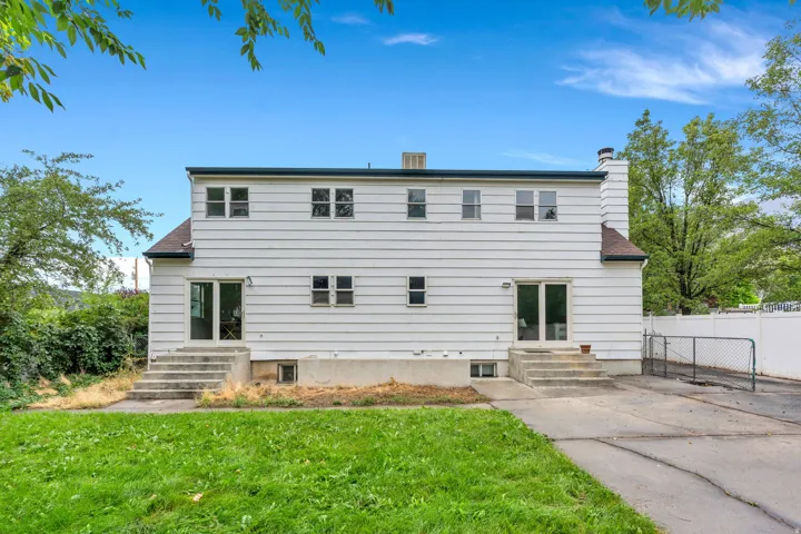 Two-story exterior with horizontal siding, multiple windows, and two sets of glass-panel doors