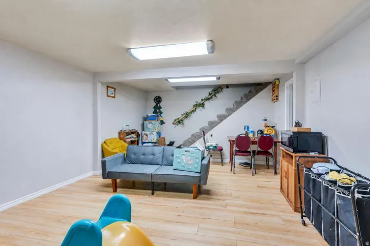 Expansive room with neutral wall tones, wood-finish flooring, and overhead lighting