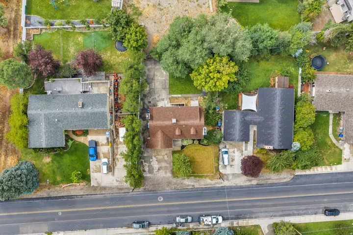 Expansive property featuring a mature landscape, paved driveway, and established trees