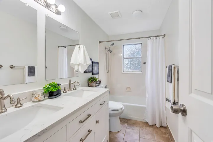 Dual vanity with undermount sinks, brushed nickel fixtures, and a white countertop