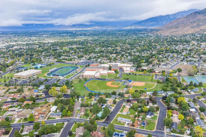 Neighborhood setting with residential streets, mature trees, and mountainous backdrop