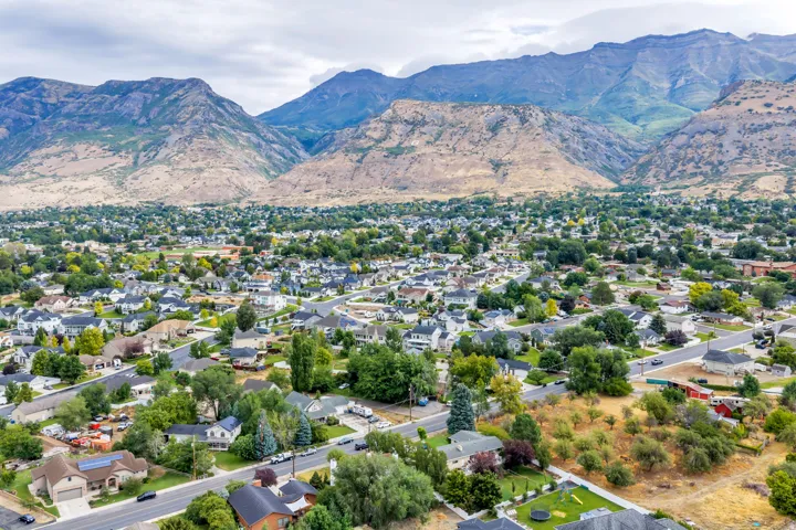 Residential neighborhood with mature trees, established streets, and mountain backdrop