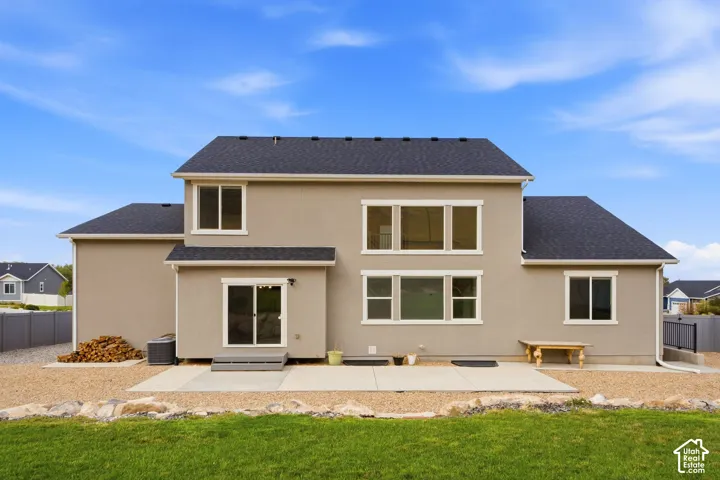 Stucco exterior with multiple windows, a rear patio, and a sliding glass door