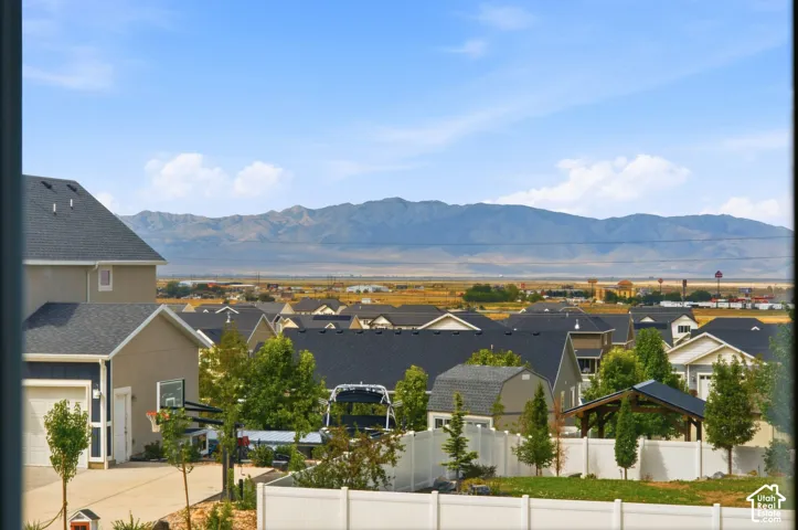 Expansive mountain backdrop with neighborhood rooftops and distant structures