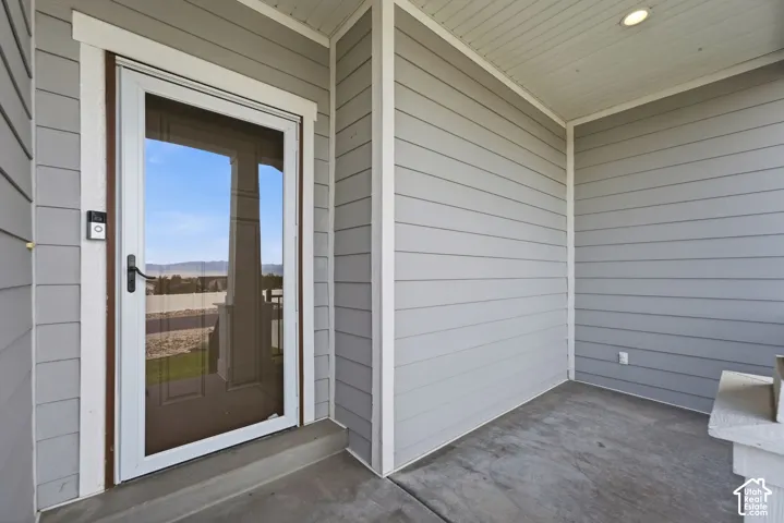 Covered entry with concrete flooring, recessed lighting, and horizontal siding