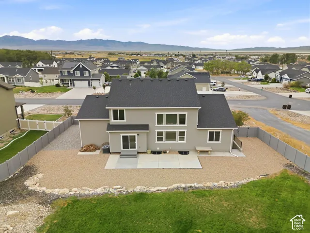 Two-story residence with a dark shingle roof, neutral stucco exterior, and white-framed windows