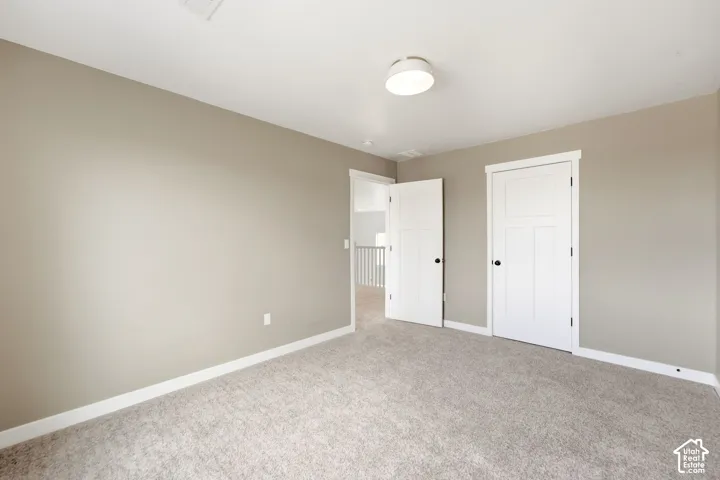Neutral wall paint, light-toned carpet, and white trim