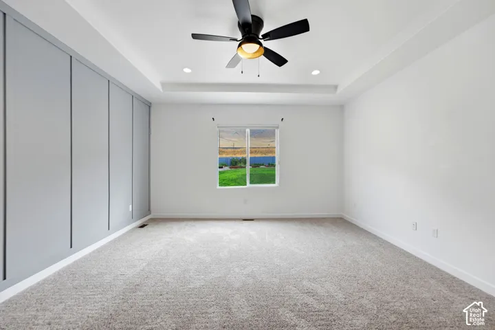 Tray ceiling with recessed lighting and a central ceiling fan