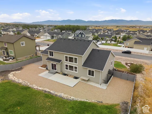 Two-story stucco exterior with a dark shingle roof