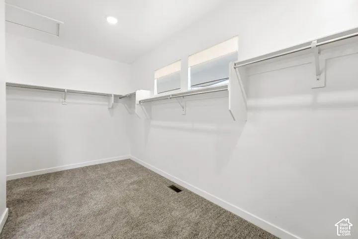 Built-in closet shelving and hanging rods, recessed ceiling lighting, and carpet flooring