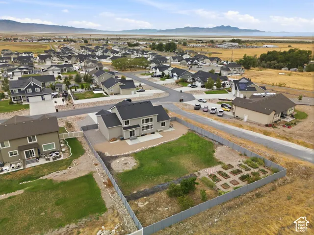 Expansive property featuring a two-story residence, a large grassy yard, fenced perimeter, and a dedicated garden area