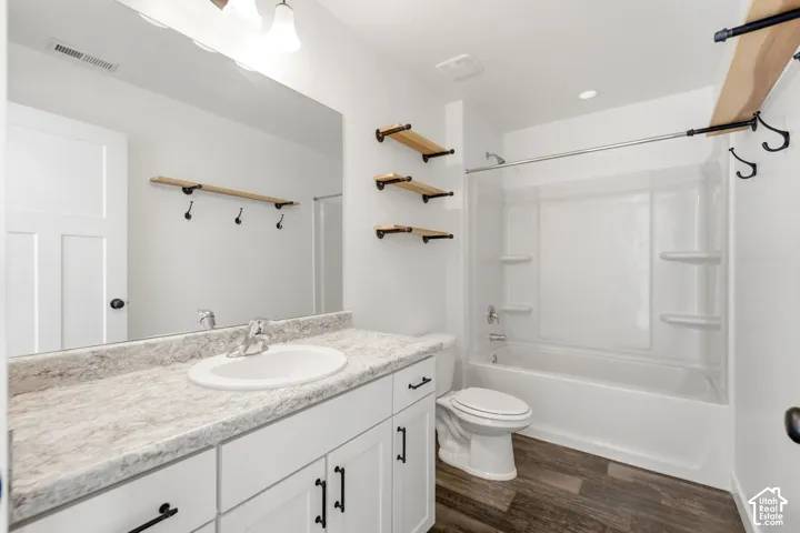 White vanity with dark hardware, a spacious countertop, and an integrated sink