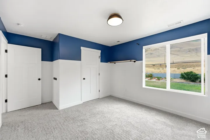 Expansive window, two-tone wall treatment, craftsman-style doors, built-in shelving, and ceiling-mounted light fixture