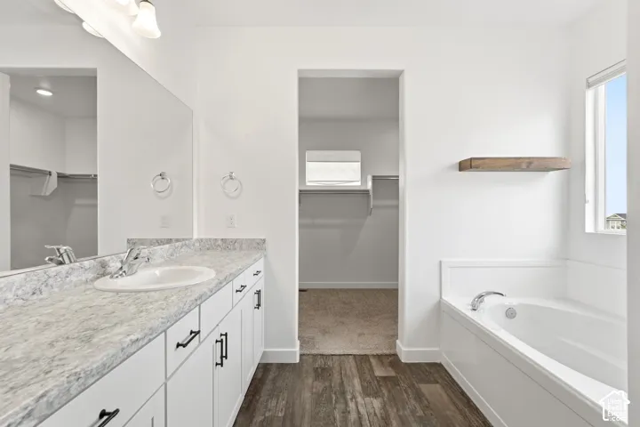White vanity with black hardware, integrated sink, and stone-finish countertop