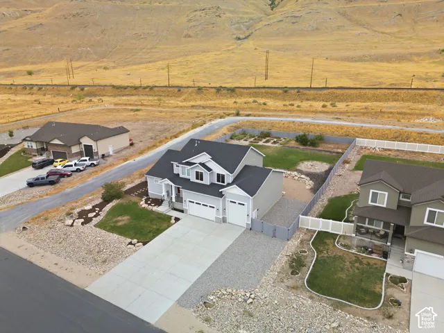 Contemporary two-story residence with a light gray exterior, a two-car garage, and an additional single-car garage