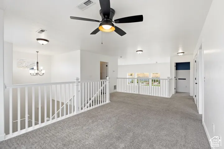Carpeted upper level with white painted railing, ceiling fan, recessed lighting, and multiple windows