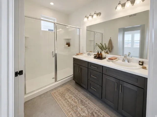Dual vanity with dark wood-finish cabinetry, white countertops, and chrome fixtures