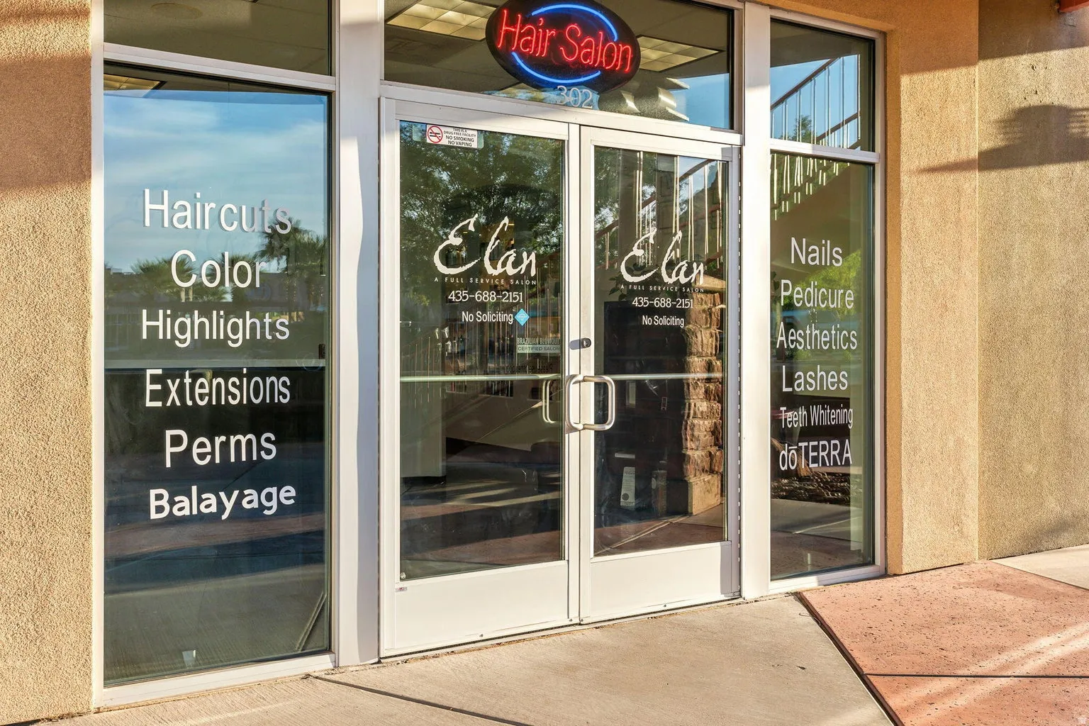 Commercial storefront with expansive glass frontage, dual entry doors with metal hardware, and exterior stucco finish