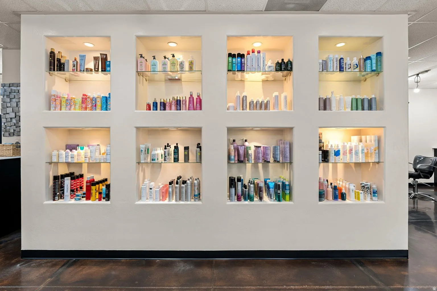 Recessed wall display niches with integrated lighting, glass shelving, and a dark floor finish