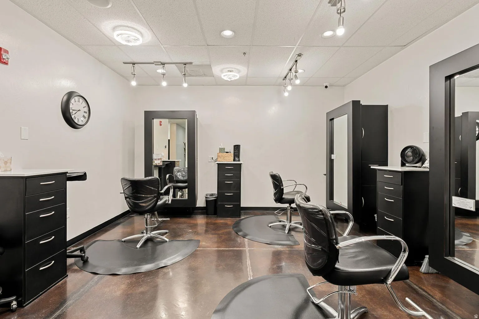 Polished concrete flooring with a high-gloss finish, track lighting, ceiling-mounted light fixtures, and white walls
