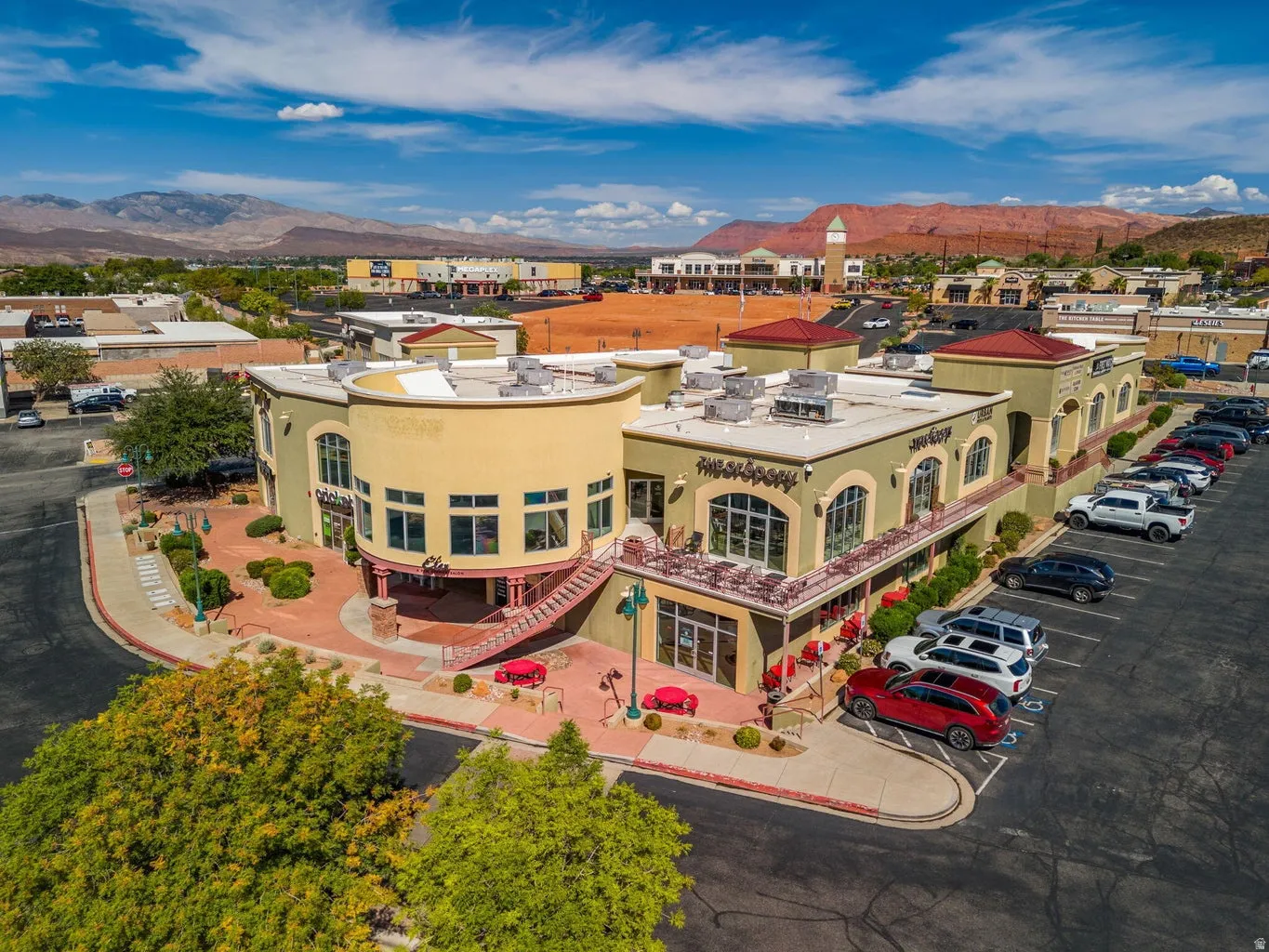 Multi-story commercial building with stucco exterior, arched windows, and a red tile roof