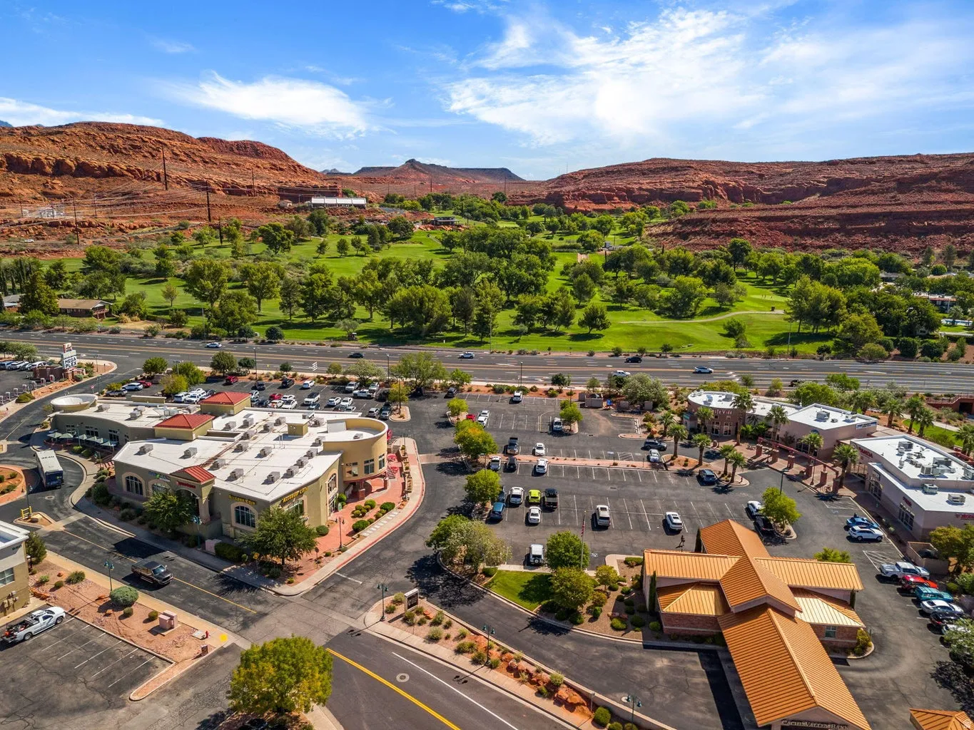 Expansive commercial complex with multiple buildings, surface parking, and mature landscaping