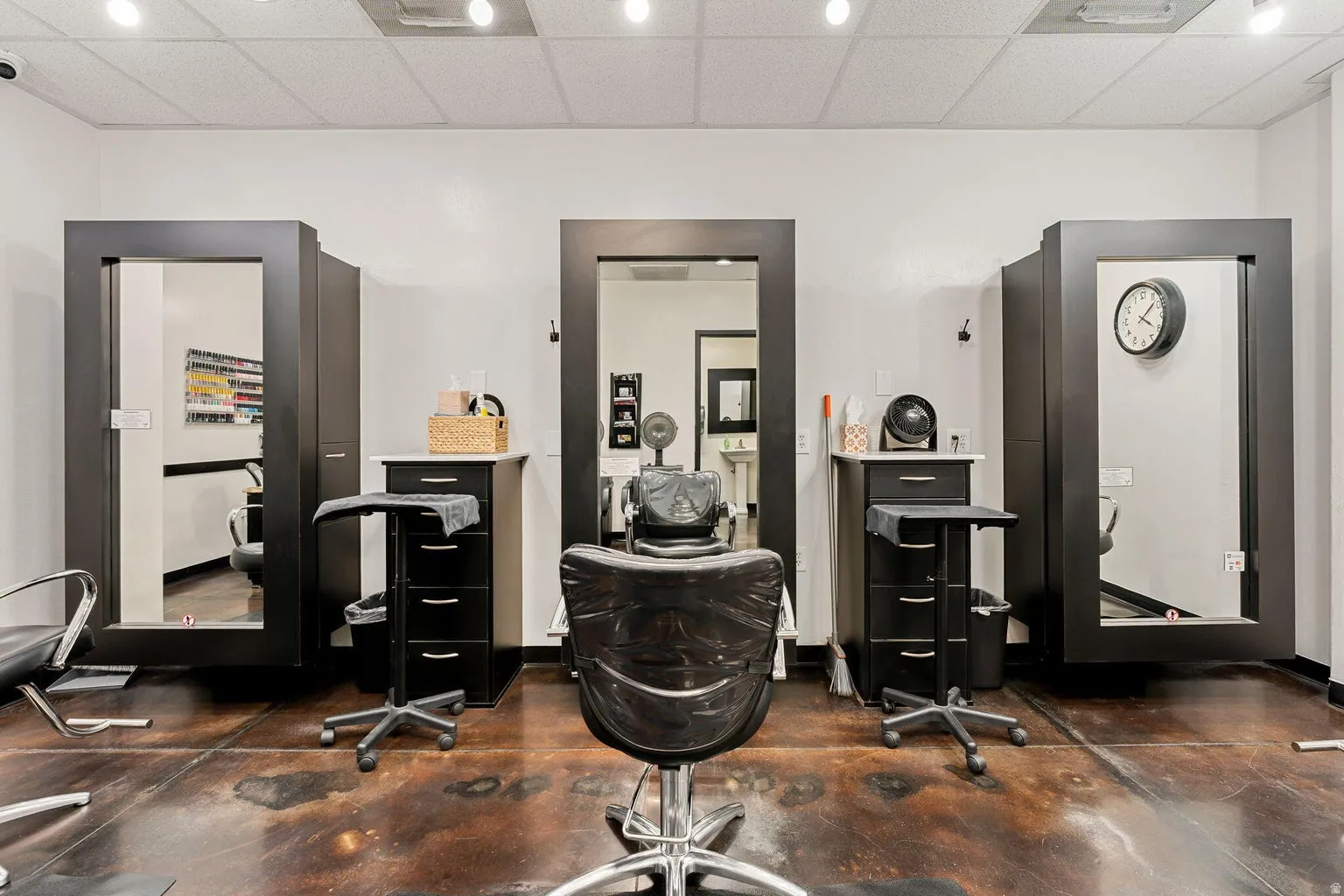 Three distinct service stations with large framed mirrors, individual storage cabinetry, and durable flooring