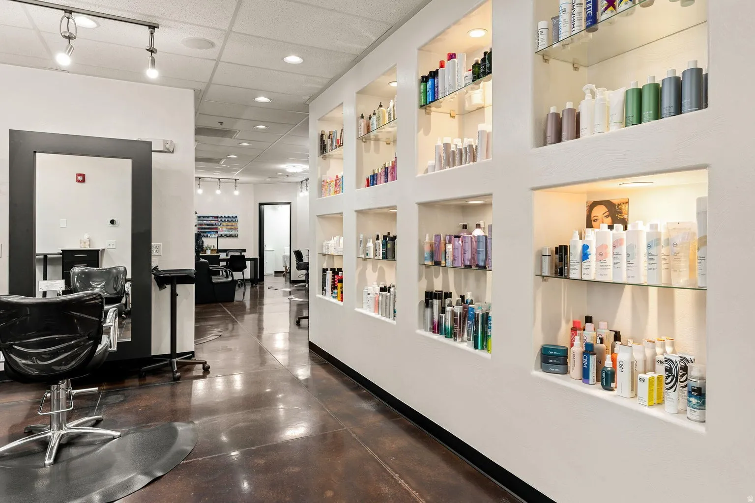 Recessed wall shelving with integrated lighting, track lighting, and polished concrete flooring