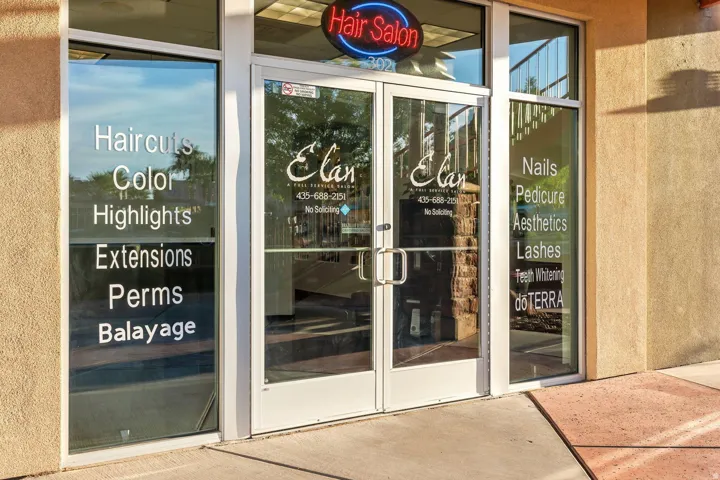 Commercial storefront with expansive glass frontage, dual entry doors with metal hardware, and exterior stucco finish