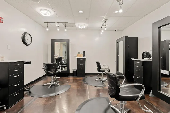 Polished concrete flooring with a high-gloss finish, track lighting, ceiling-mounted light fixtures, and white walls