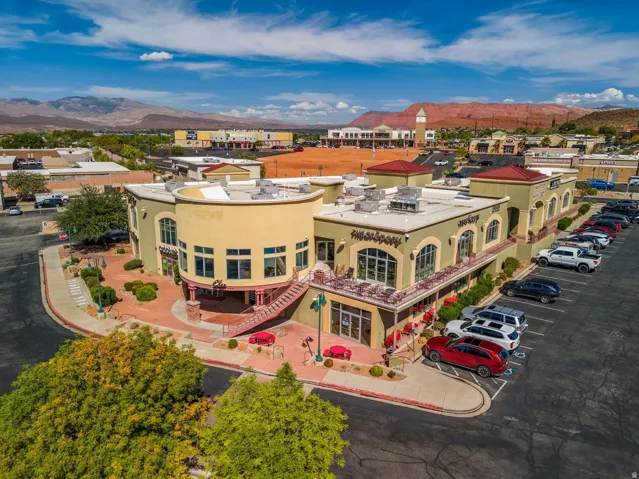 Multi-story commercial building with stucco exterior, arched windows, and a red tile roof