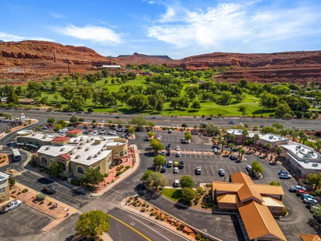 Expansive commercial complex with multiple buildings, surface parking, and mature landscaping