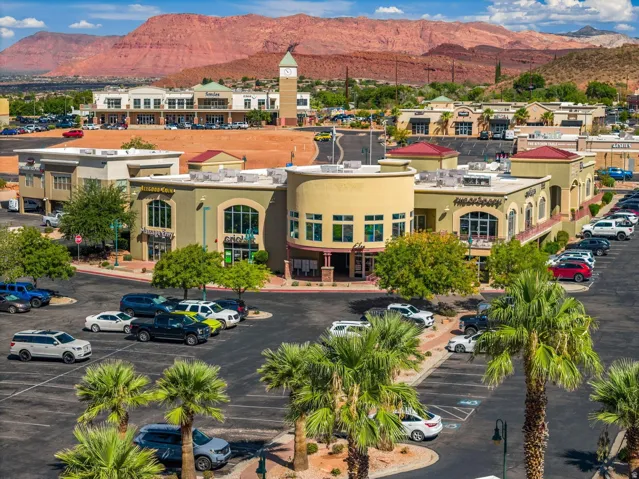 Commercial buildings featuring stucco exteriors and arched windows, with a clock tower prominent in the background